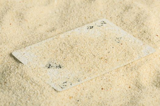 Poker playing cards buried  in a sand dune