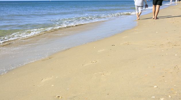 Old people taking a walk on the beach