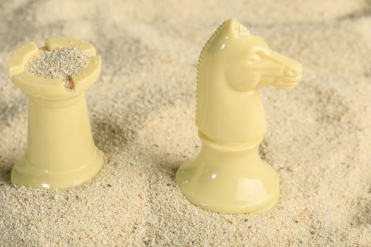 Chess pieces in a sand dune