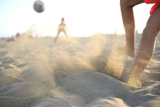 Boy playing football  on the beach