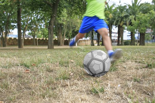 Green eyes boy  playing football the park