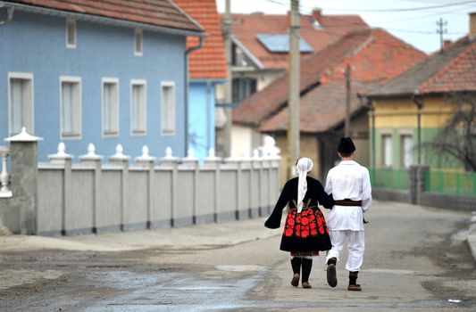 Couple wearing traditional costume walking towards village