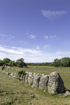 Stone ship on Gotland, Sweden with a partly cloudy sky.