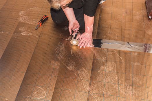 Woman in the laying of plastic laminate or vinyl
