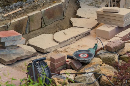 Man cutting stone slabs, concrete slab with an electric grinder