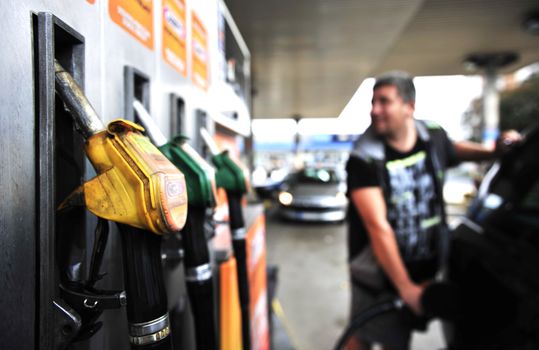 Man holding Gasoline pistol at gas station
