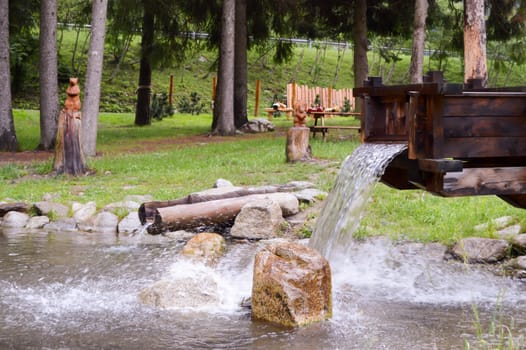 Artificial waterfall In a small pond in a natural park in the dolomites in Italy