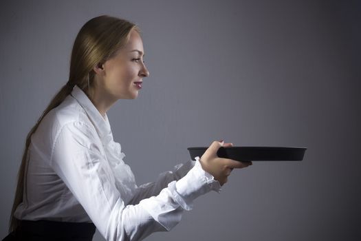 Young blonde woman waitress with a tray in hands