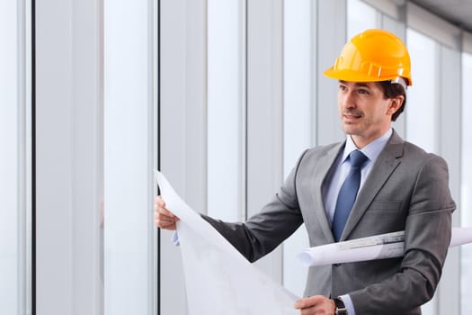 Architector in hardhat and business suit with construction plans