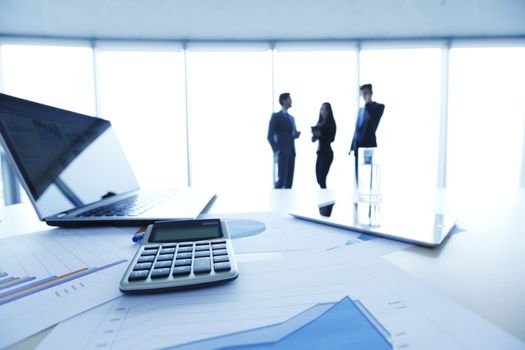 Businessmen in office with table with laptop and financial documents with diagrams 