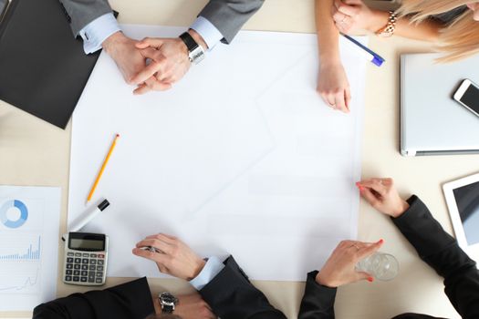 Business people sitting at table with electronic devices on meeting