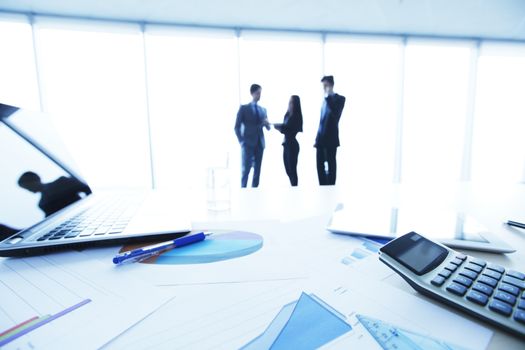 Financial reports, calculator and laptop on table in office