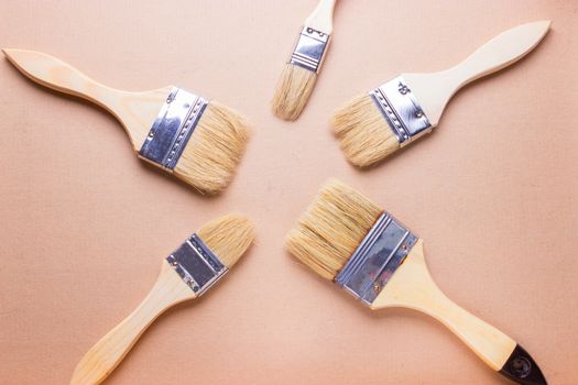 new different size paintbrushes on wood floor