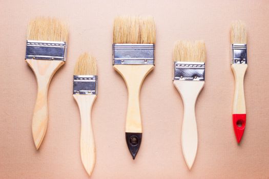 new different size paintbrushes on wood floor