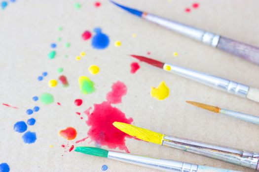 Row of artist paintbrushes closeup on artistic background.