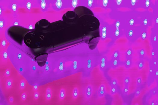 Game controller on illuminated table background. different colors
