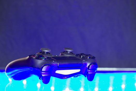 Game controller on illuminated table background. different colors