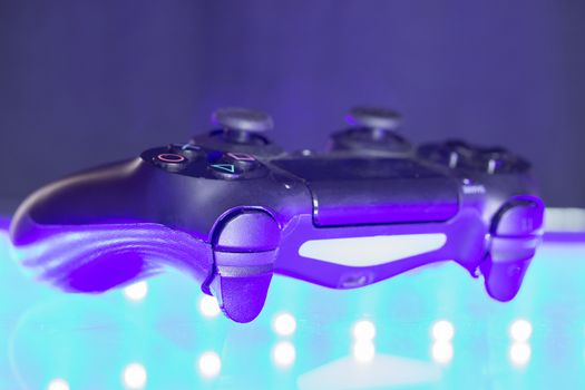 Game controller on illuminated table background. different colors