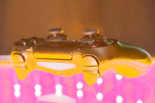 Game controller on illuminated table background. different colors