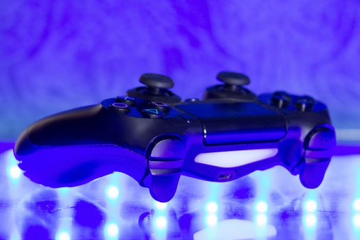 Game controller on illuminated table background. different colors