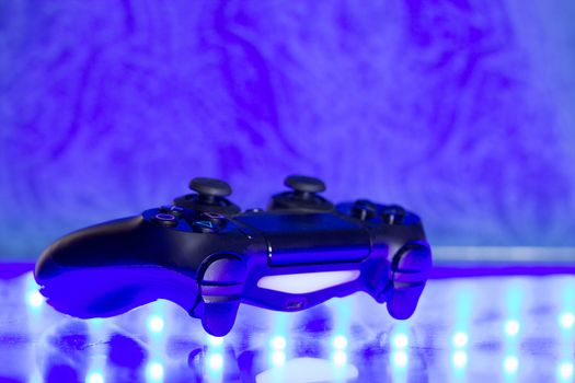 Game controller on illuminated table background. different colors