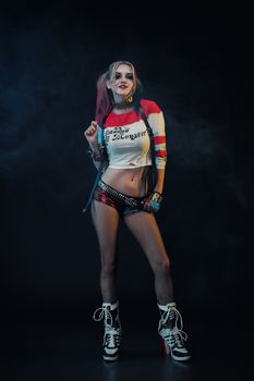 Cosplayer girl with in Harley Quinn costume. Halloween make up.