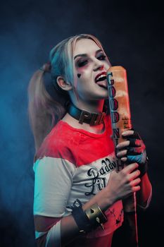 Cosplayer girl with in Harley Quinn costume. Halloween make up.