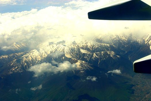 plain wing and mountains with snow below