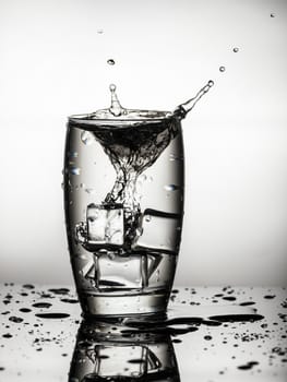 Splashing water from a glass with ice cubes