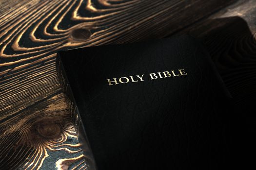 Holy Bible on old wooden church table, top view