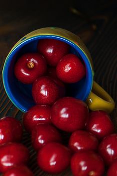 Fresh cherries in jar on the wooden background. Selective focus. Focus on the right cherries in front of jar.