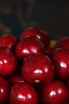 Fresh cherries in jar on the wooden background. Selective focus. Focus on the right cherries in front of jar.