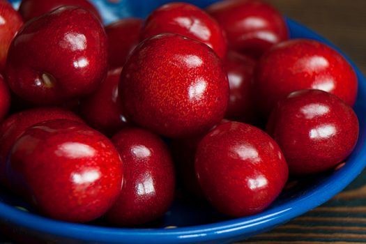 Fresh cherries in jar on the wooden background. Selective focus. Focus on the right cherries in front of jar.