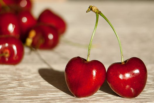 Fresh cherries in jar on the wooden background. Selective focus. Focus on the right cherries in front of jar.