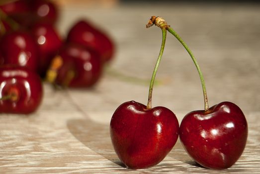 Fresh cherries in jar on the wooden background. Selective focus. Focus on the right cherries in front of jar.