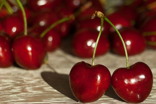 Fresh cherries in jar on the wooden background. Selective focus. Focus on the right cherries in front of jar.