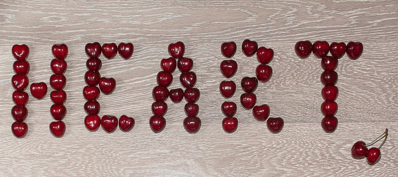 Fresh cherries in jar on the wooden background. Selective focus. Focus on the right cherries in front of jar.