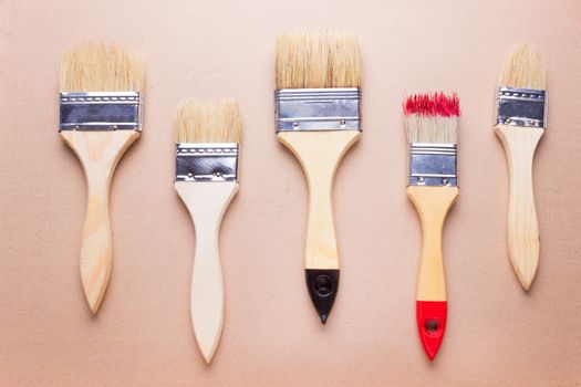 new different size paintbrushes on wood floor