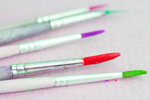 Row of artist paintbrushes closeup on white background.