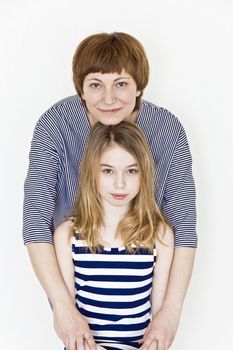 Happiest mother and daughter playing with blond long hair near white wall