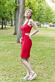 Beautiful lady in red are standing at the summer day