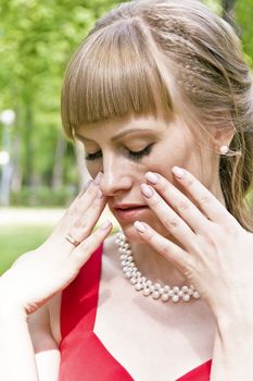 Portrait of beautiful girl in red with white pearls