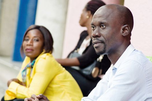The gentleman sitting next to his  women and looking in different directions