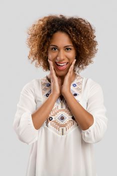 Beautiful African American woman smiling, isolated over a gray background