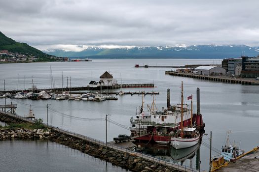 Harbour in Tromso and mountains on background in a cloudy day, Norway