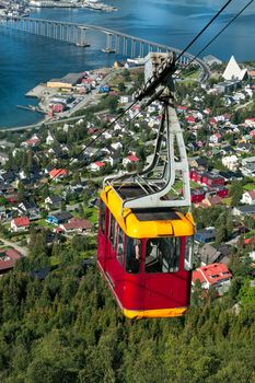 Cable car above Tromso city with the bridge and Arctic Cathedral on background, Norway