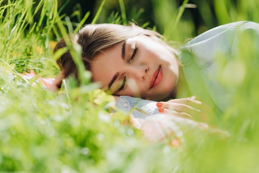 Beautiful young woman sleeping on fresh spring grass in park