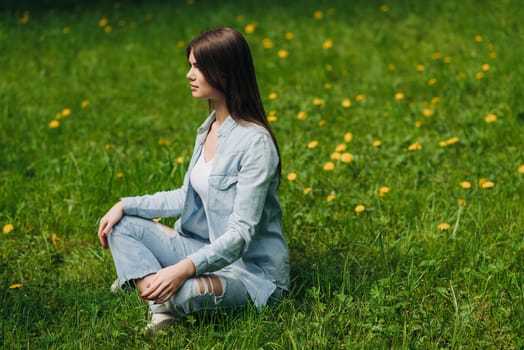 Beautiful young girl in casual clothes meditating in spring park