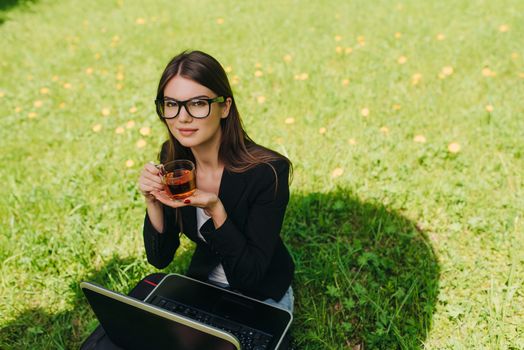 Beautiful business woman in suit using laptop computer in the park