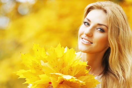 Portrait of a beautiful smiling woman in the autumn park